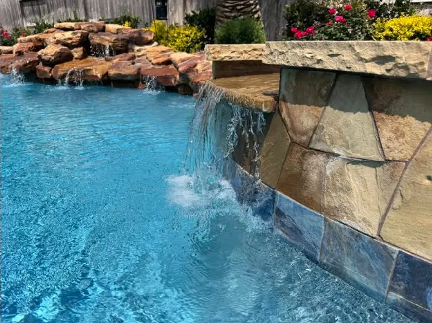 Stone waterfall spilling into pool